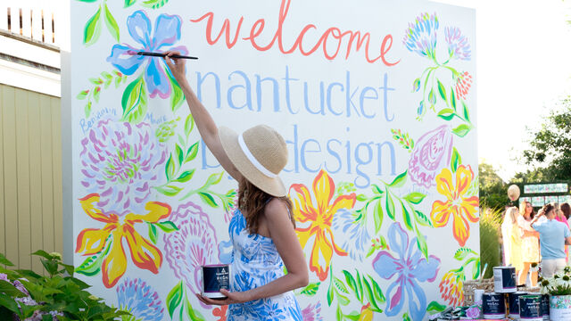 Print artist painting a sign at an event